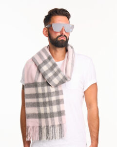 A high-fashion editorial shot of a red tartan cashmere scarf.