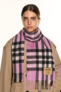 Artisan hands weaving Scottish cashmere on a traditional loom, showcasing premium material.