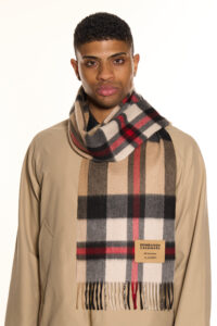 A folded light brown cashmere scarf in a luxury signature box.