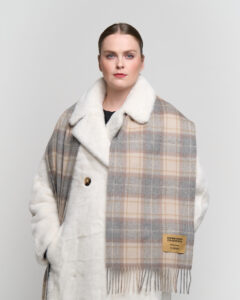 Classic tartan and solid scarves displayed to show heritage craftsmanship